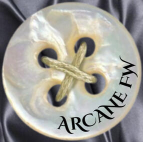 pearlescent white button with the text ARCANE FW in fancy script written around the rim